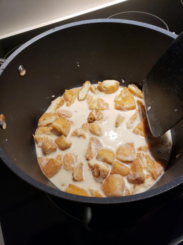 Chopped up donuts in a pot with oat milk
